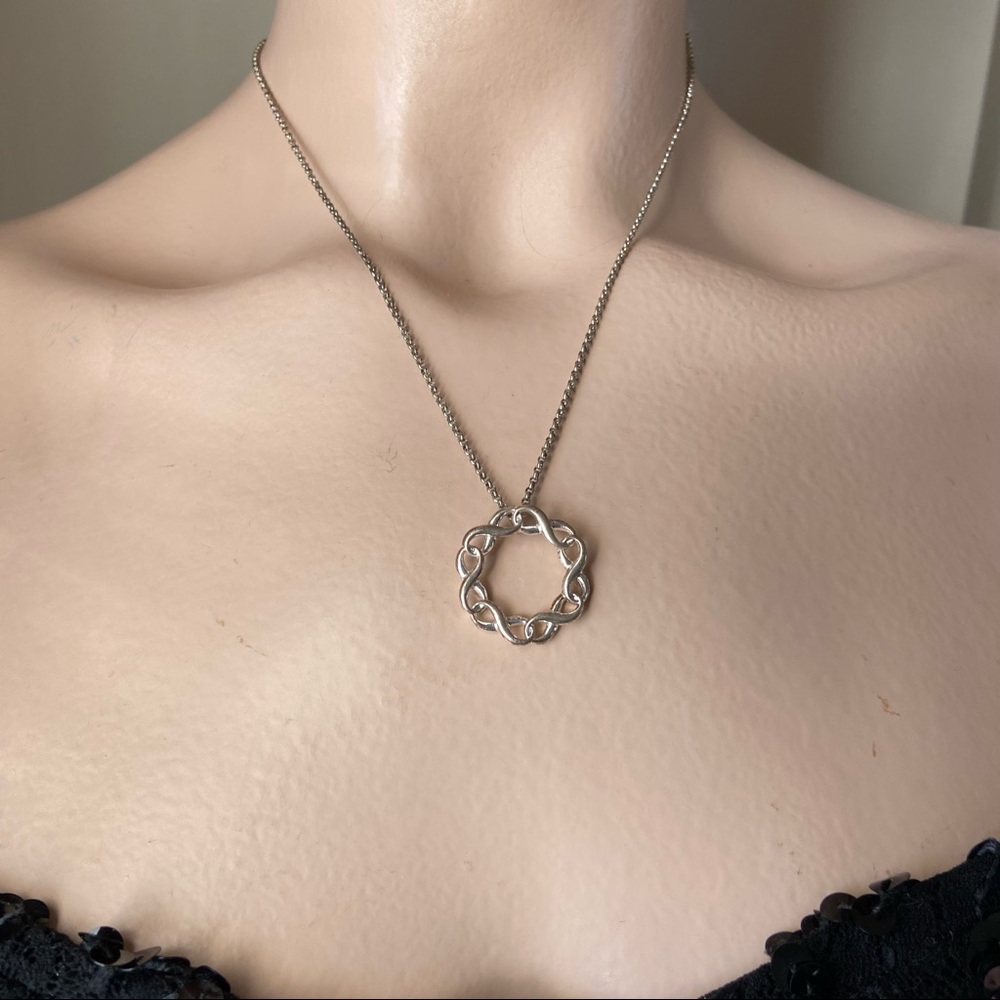 SAQ stamped women silver tone infinity twist circle pendant necklace. Used.